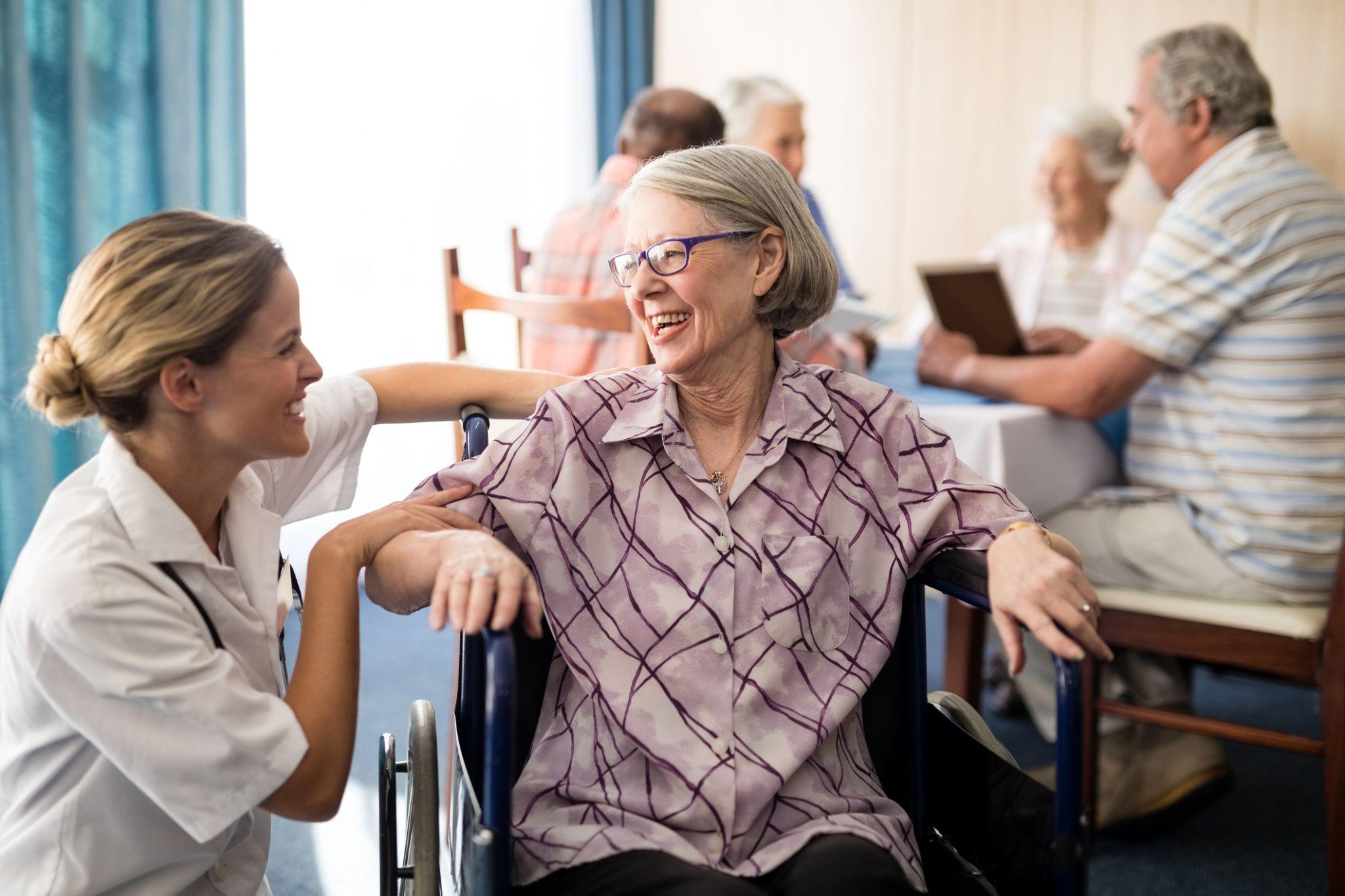 Healthcare professionals assisting a patient with physical therapy in a nursing home